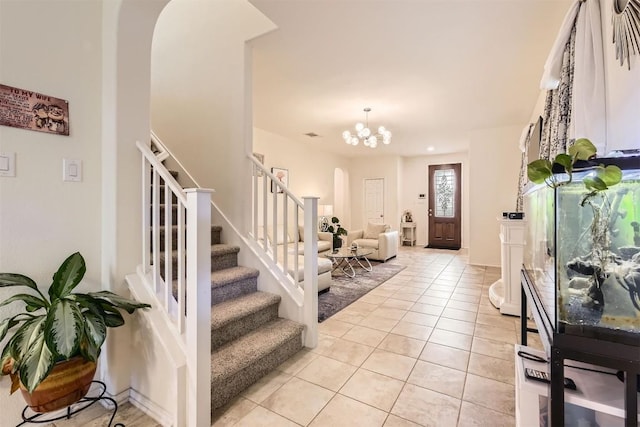 entryway with a notable chandelier and light tile patterned floors