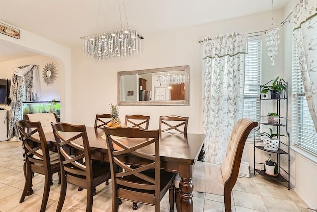 dining area with light tile patterned floors and a notable chandelier