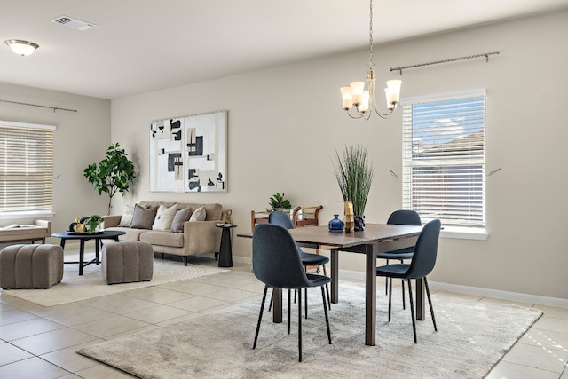 tiled dining space featuring an inviting chandelier