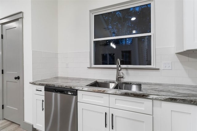 kitchen with light hardwood / wood-style flooring, white cabinetry, stainless steel dishwasher, and sink