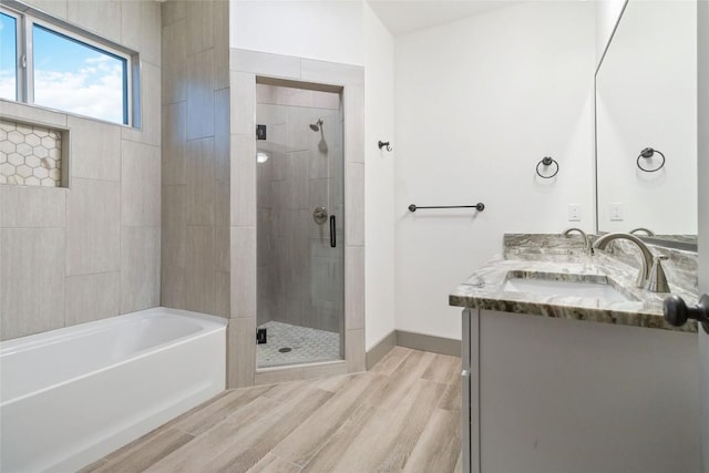 bathroom with hardwood / wood-style flooring, vanity, and separate shower and tub