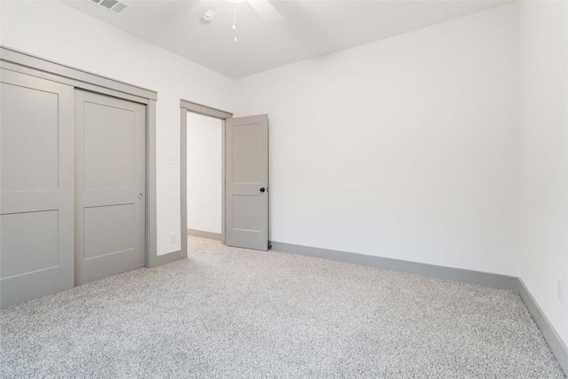 unfurnished bedroom featuring ceiling fan, a closet, and light carpet