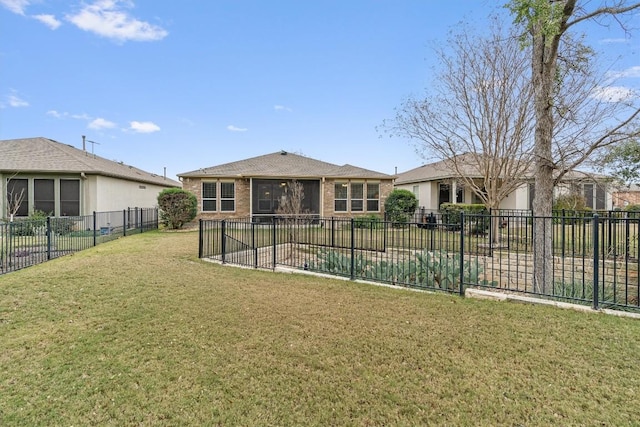 back of property featuring a yard, brick siding, and a fenced backyard