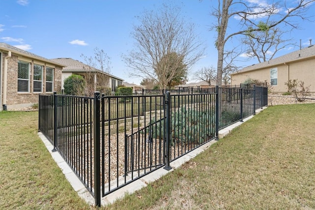 view of gate featuring a yard and fence