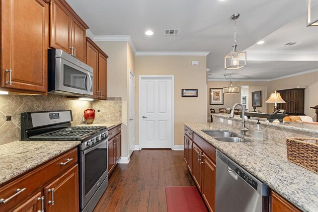 kitchen featuring sink, crown molding, light stone countertops, decorative light fixtures, and stainless steel appliances