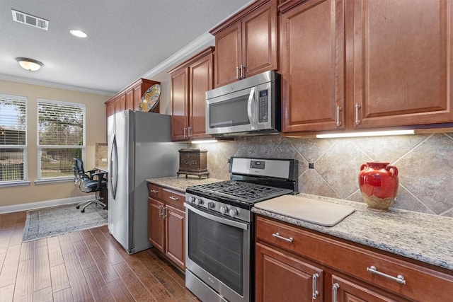 kitchen with backsplash, light stone counters, ornamental molding, stainless steel appliances, and dark hardwood / wood-style floors