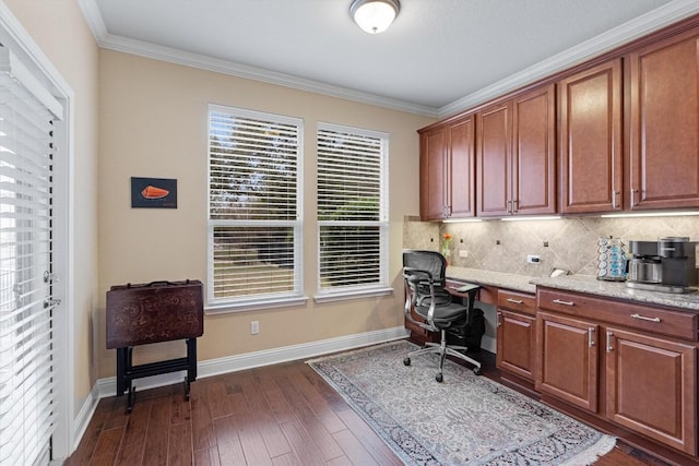 office area with built in desk, dark wood-type flooring, and crown molding