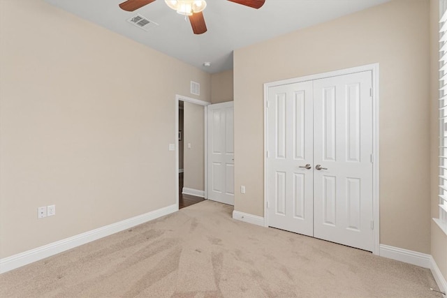 unfurnished bedroom with carpet floors, baseboards, visible vents, and a closet