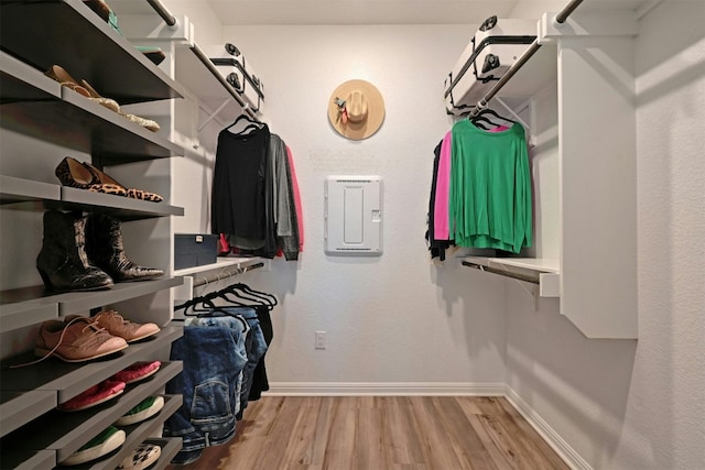 walk in closet with light hardwood / wood-style flooring