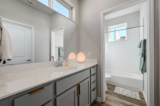 full bathroom with vanity, toilet, wood-type flooring, and plenty of natural light