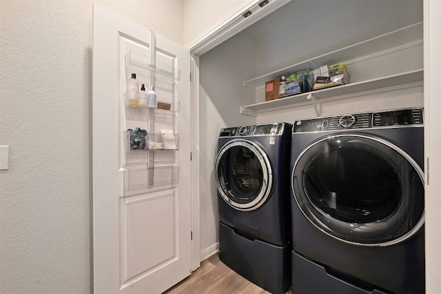 laundry area with washer and dryer and light hardwood / wood-style floors