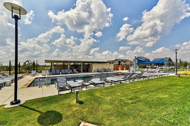 view of swimming pool with a yard