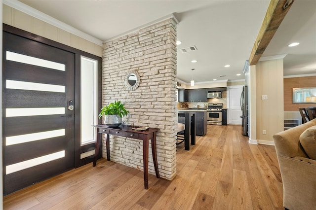 foyer with light hardwood / wood-style flooring and crown molding