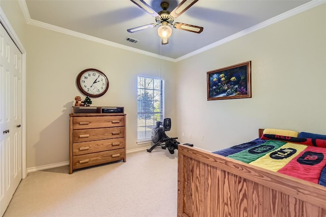 carpeted bedroom with ceiling fan, a closet, and crown molding