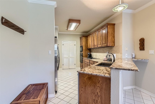 kitchen with kitchen peninsula, light stone counters, ornamental molding, sink, and light tile patterned floors