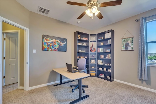 carpeted home office featuring ceiling fan