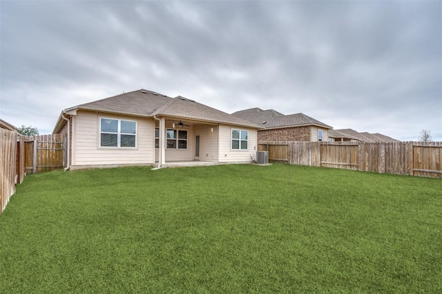 back of property with central AC, ceiling fan, and a yard