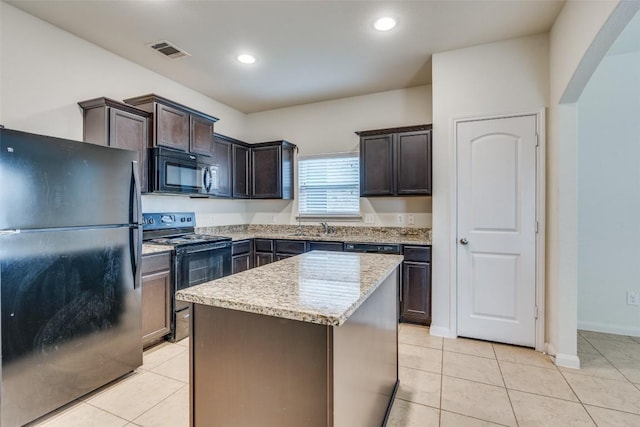 kitchen with light tile patterned flooring, a center island, dark brown cabinetry, and black appliances