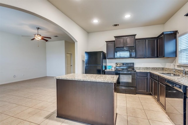 kitchen with black appliances, a kitchen island, light tile patterned flooring, and sink