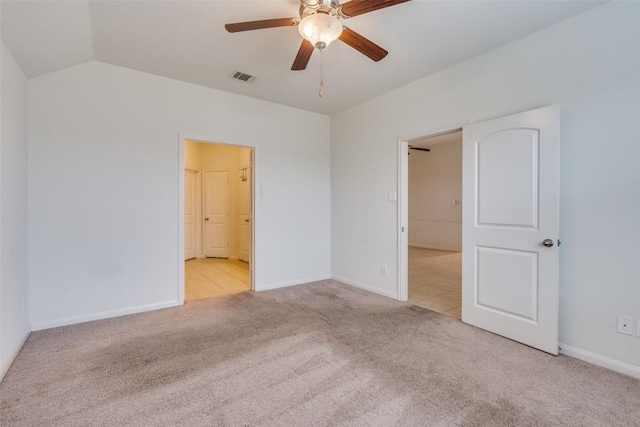 spare room featuring ceiling fan, light colored carpet, and vaulted ceiling