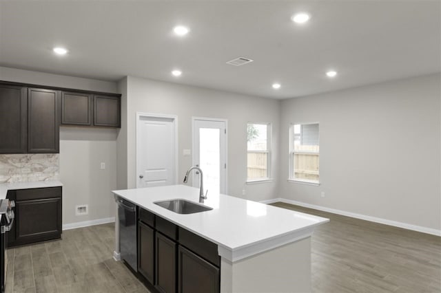 kitchen featuring sink, light hardwood / wood-style flooring, dishwasher, an island with sink, and stove