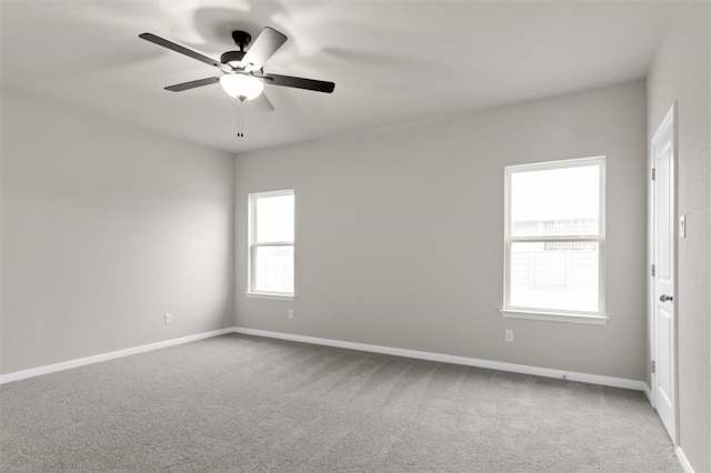 unfurnished room with ceiling fan and carpet