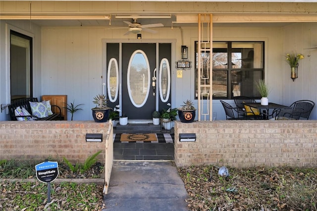 entrance to property with ceiling fan and a porch