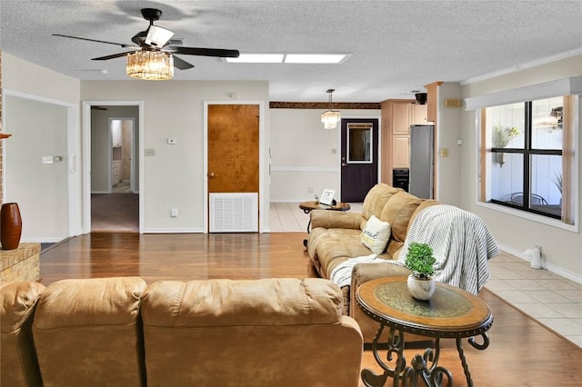 tiled living room featuring ceiling fan and a textured ceiling