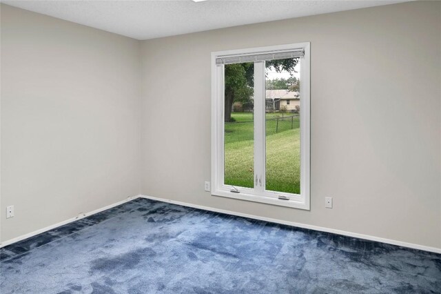 spare room with dark carpet