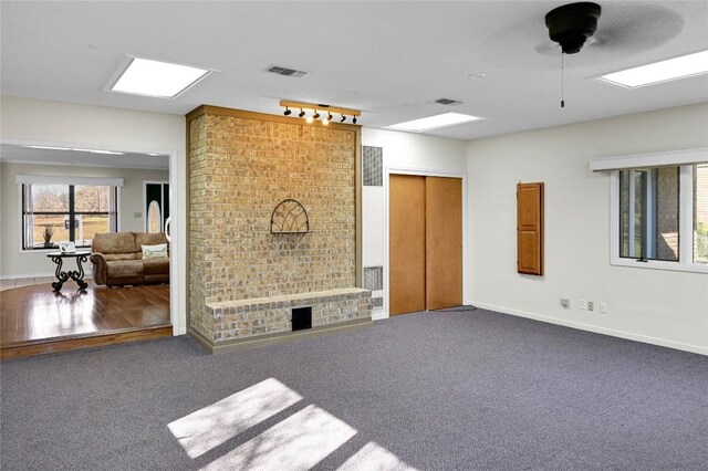 living room featuring carpet flooring, ceiling fan, a wealth of natural light, and track lighting