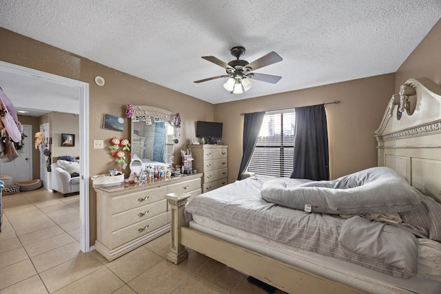 bedroom featuring ceiling fan, light tile patterned flooring, and a textured ceiling