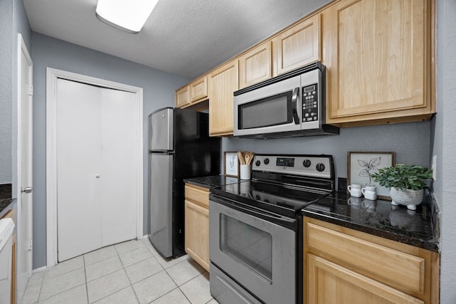 kitchen with light brown cabinets, light tile patterned floors, a textured ceiling, and appliances with stainless steel finishes