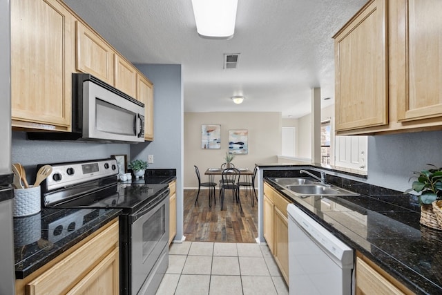 kitchen with light brown cabinets, light tile patterned floors, sink, and appliances with stainless steel finishes