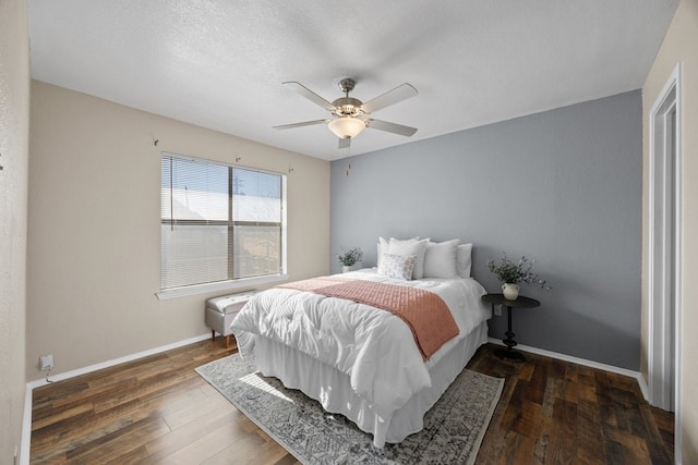 bedroom featuring a textured ceiling, dark hardwood / wood-style floors, and ceiling fan