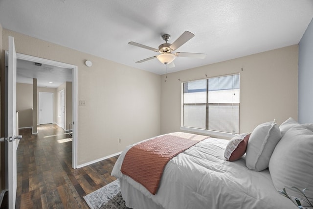 bedroom featuring a textured ceiling, ceiling fan, and dark wood-type flooring