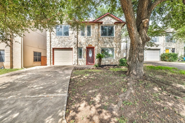 view of front of property with driveway, stone siding, and a garage