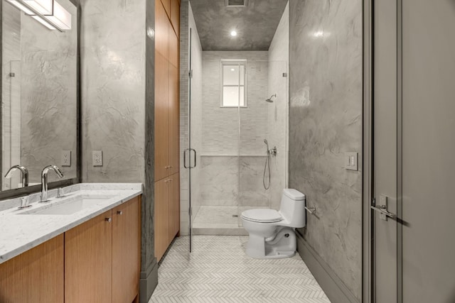 bathroom featuring tile patterned flooring, vanity, toilet, and a shower with shower door