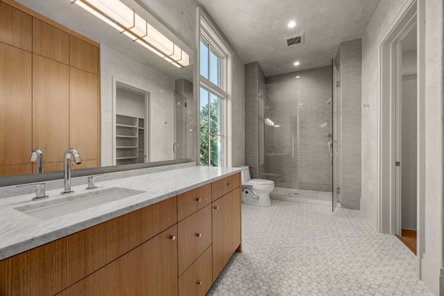 bathroom with vanity, toilet, and a shower with door