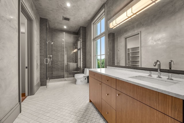 bathroom with vanity, toilet, and a shower with shower door