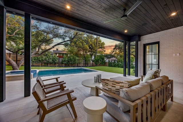 pool at dusk featuring ceiling fan, an outdoor living space, a yard, and a patio