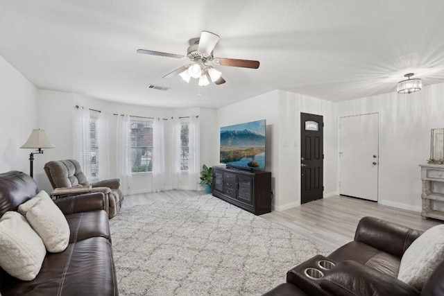 living room with ceiling fan and light wood-type flooring