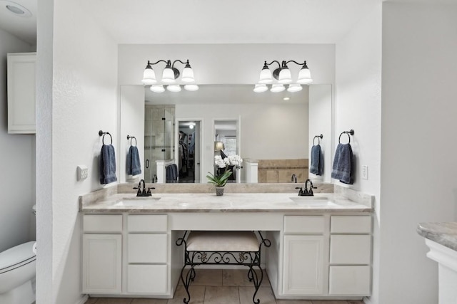 bathroom featuring tile patterned flooring, vanity, toilet, and an enclosed shower