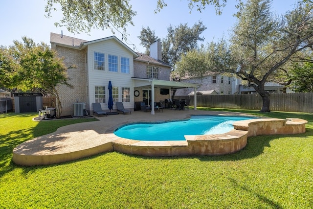 rear view of house featuring a lawn, a fenced in pool, central air condition unit, a shed, and a patio