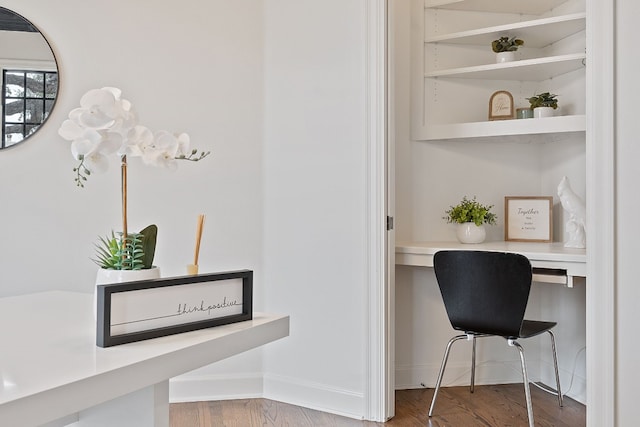 office space featuring wood-type flooring and built in desk