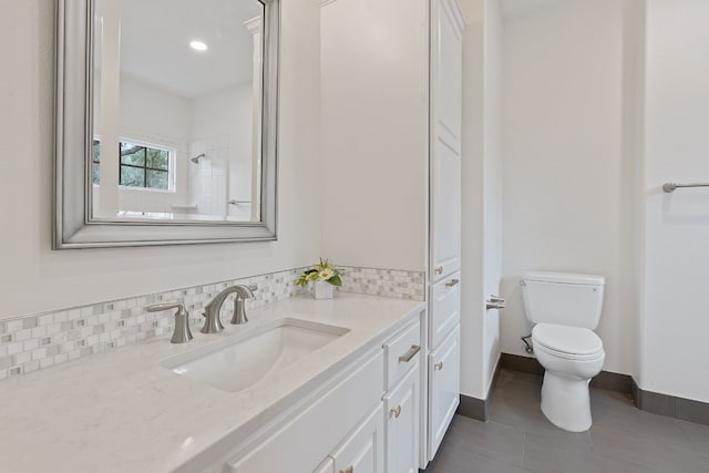 bathroom featuring tile patterned floors, vanity, toilet, and decorative backsplash