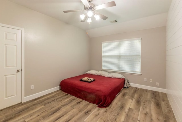 bedroom featuring ceiling fan, light hardwood / wood-style floors, and vaulted ceiling