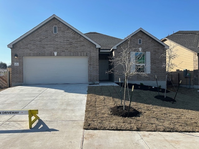 ranch-style house with driveway, an attached garage, fence, and brick siding