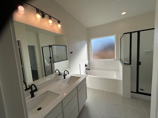 full bathroom featuring a stall shower, a garden tub, a sink, and tile patterned floors