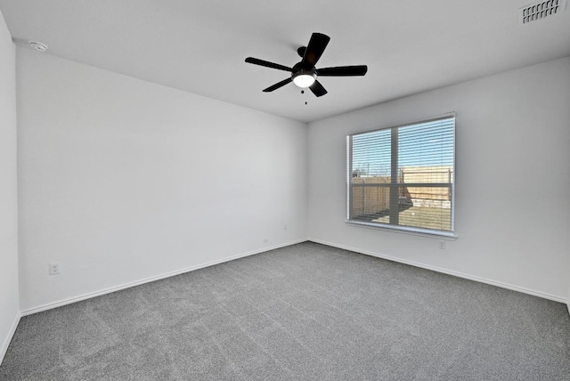 empty room featuring visible vents, baseboards, ceiling fan, and dark carpet