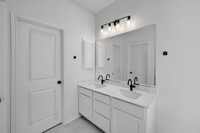 bathroom with double vanity, tile patterned floors, and a sink